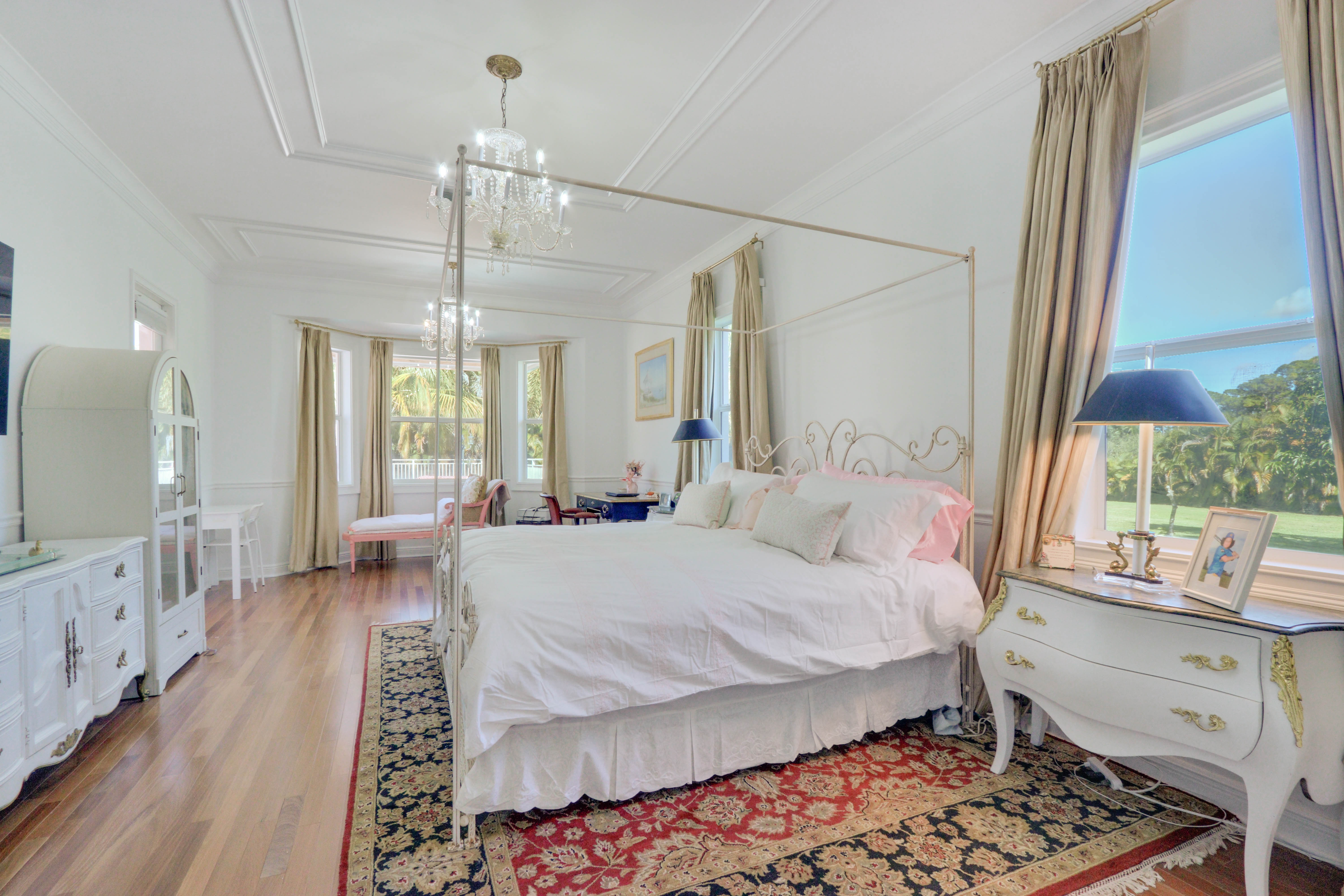 Maison Sarti Master Suite with white canopy bed, French furniture, and cream drapes
